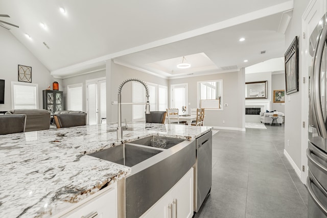 kitchen with tile floors, a healthy amount of sunlight, white cabinets, and appliances with stainless steel finishes