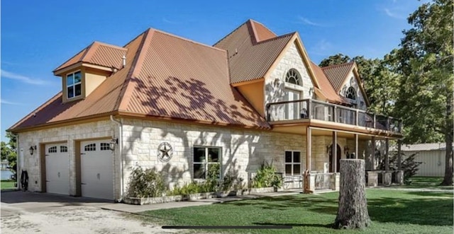 view of front facade featuring a balcony, a garage, and a front yard