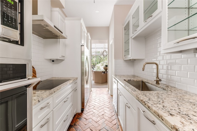 kitchen featuring white cabinets, light stone countertops, and sink