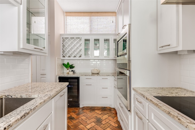 kitchen featuring white cabinetry, beverage cooler, tasteful backsplash, oven, and black electric cooktop