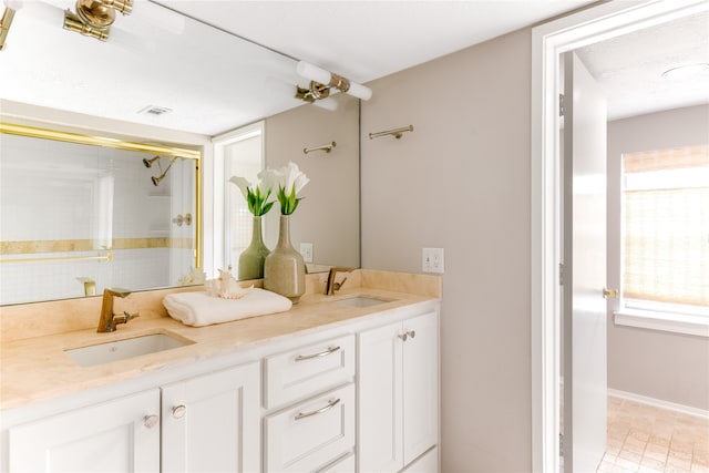 bathroom featuring tile patterned floors, vanity, and a shower with shower door