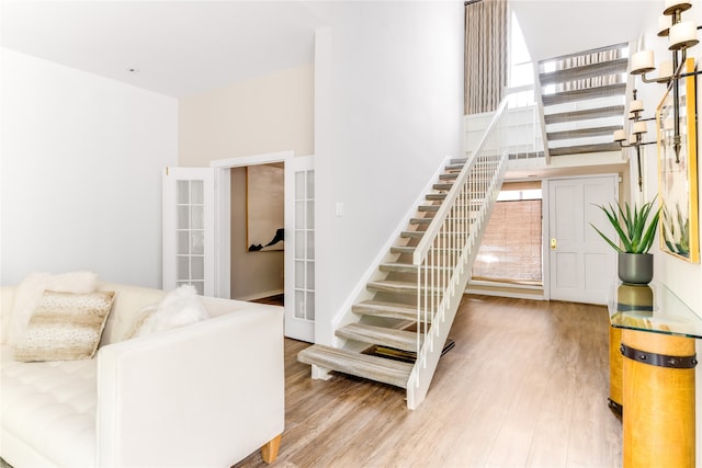 stairway with wood-type flooring and french doors