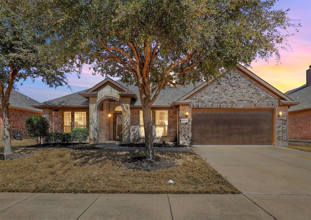 view of front of house featuring a garage, concrete driveway, brick siding, and a front lawn