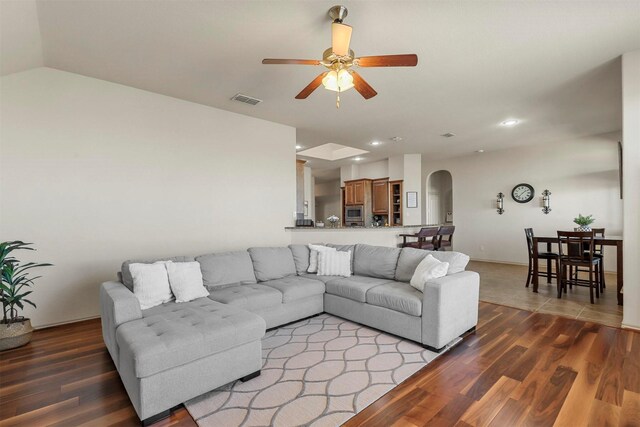 living room featuring visible vents, arched walkways, wood finished floors, and recessed lighting