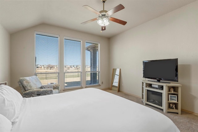 bedroom featuring carpet flooring, vaulted ceiling, baseboards, and ceiling fan