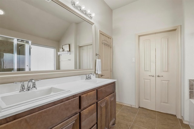 full bath featuring a shower stall, double vanity, a sink, and tile patterned floors