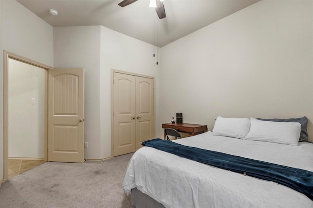 carpeted bedroom with high vaulted ceiling, a ceiling fan, and a closet