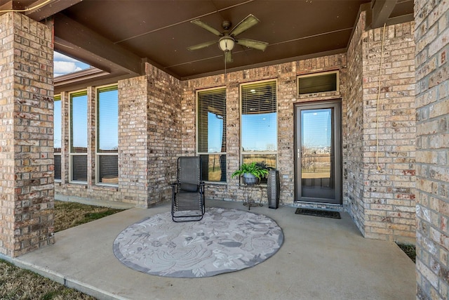 property entrance featuring brick siding and a ceiling fan