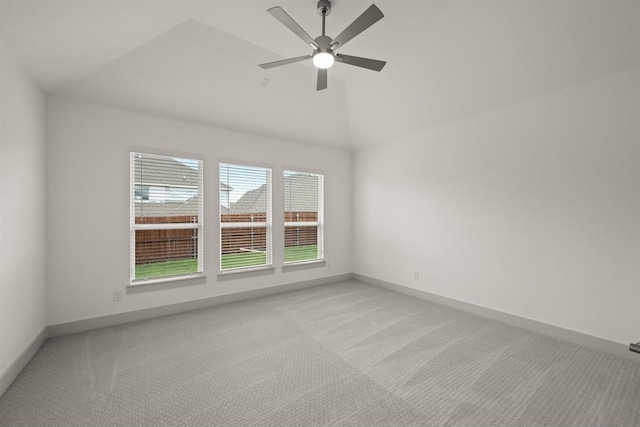 unfurnished room featuring baseboards, light carpet, a ceiling fan, and vaulted ceiling