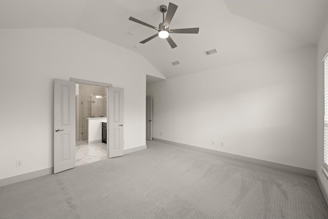 unfurnished bedroom featuring visible vents, ensuite bathroom, baseboards, lofted ceiling, and light colored carpet