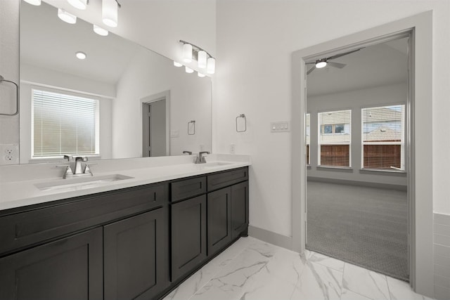 bathroom with double vanity, a ceiling fan, marble finish floor, and a sink