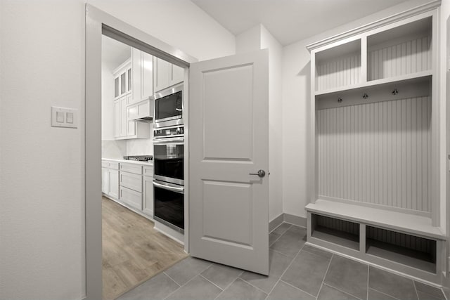 mudroom featuring light tile patterned floors and baseboards