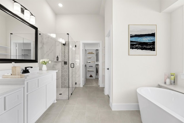 bathroom with tile patterned floors, a walk in closet, a stall shower, a soaking tub, and vanity