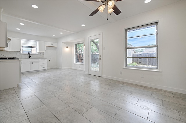 unfurnished living room with light tile patterned floors and ceiling fan