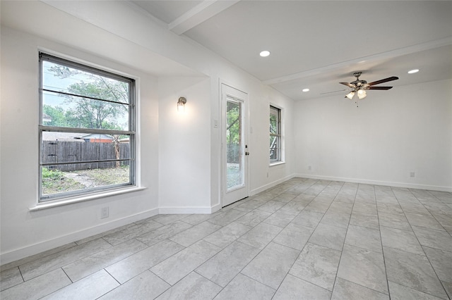 empty room featuring beam ceiling, plenty of natural light, and ceiling fan