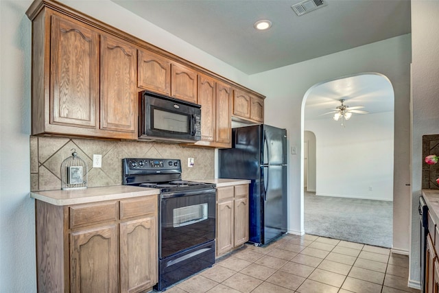 kitchen featuring decorative backsplash, light tile patterned floors, ceiling fan, and black appliances