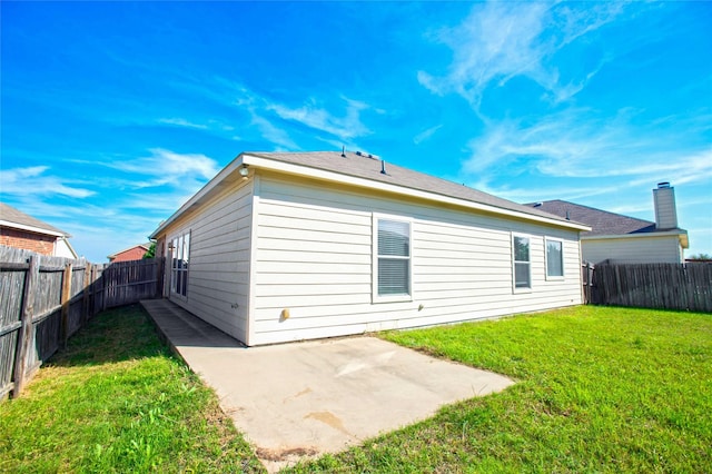 back of house with a lawn and a patio