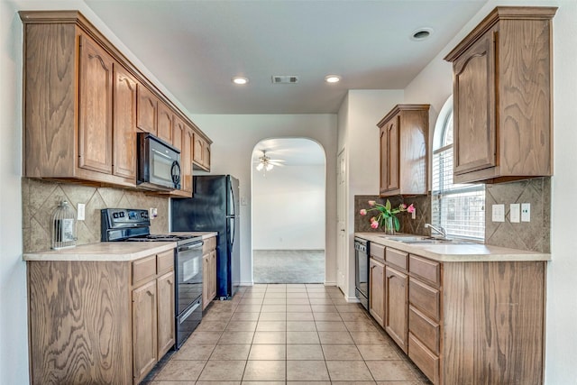 kitchen featuring black appliances, ceiling fan, decorative backsplash, and light tile patterned floors