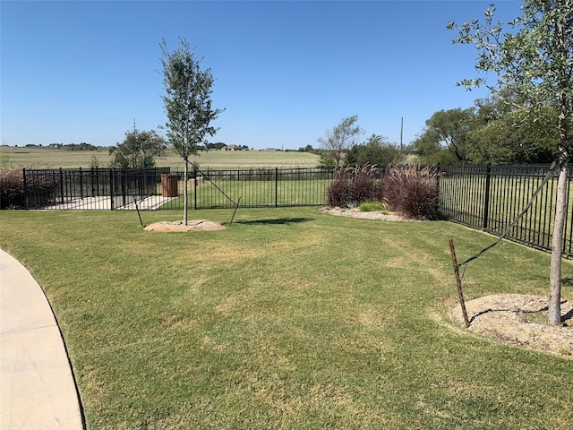 view of yard with fence and a rural view