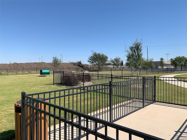 view of gate with fence and a lawn