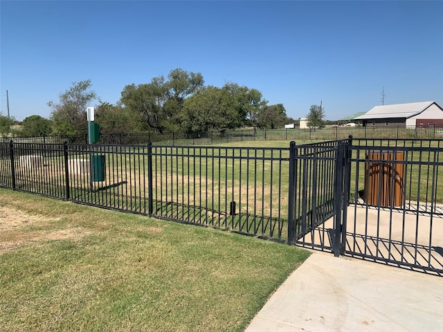 view of gate featuring fence and a yard