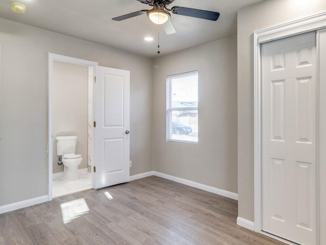 unfurnished bedroom with ceiling fan, light hardwood / wood-style floors, ensuite bathroom, and a closet