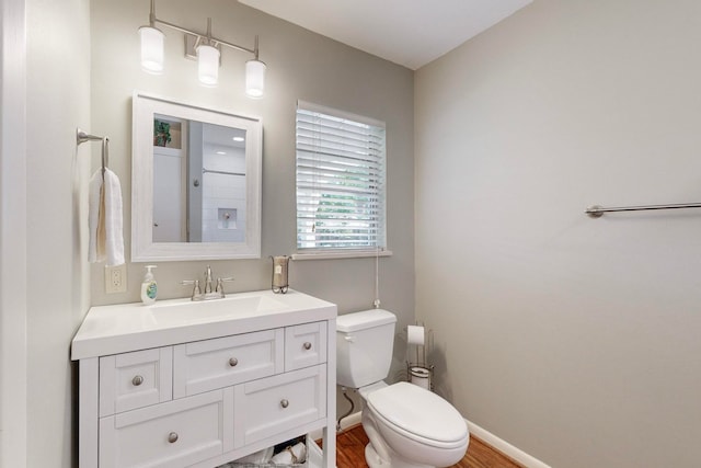 bathroom featuring wood-type flooring, vanity, and toilet