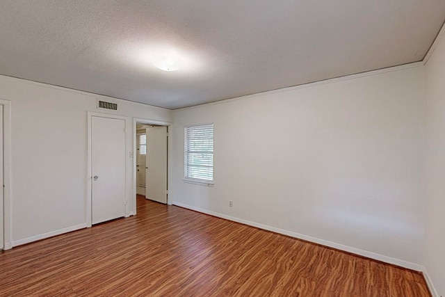 unfurnished room featuring hardwood / wood-style flooring and a textured ceiling