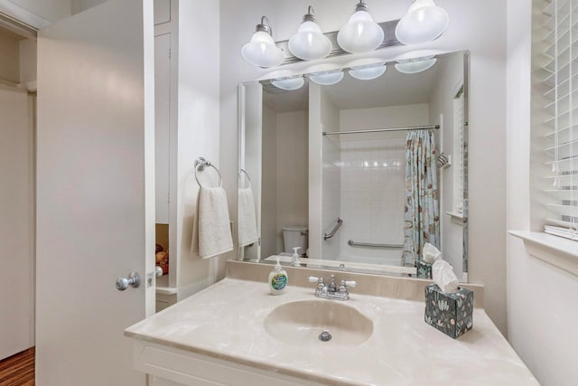 bathroom featuring walk in shower, vanity, and toilet