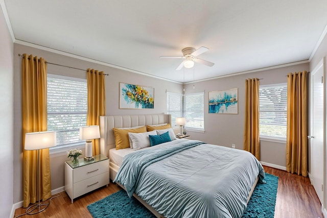 bedroom featuring ceiling fan, multiple windows, and hardwood / wood-style floors