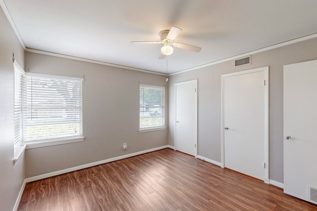 spare room with ceiling fan, dark wood-type flooring, and crown molding