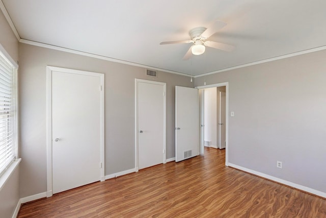 unfurnished bedroom featuring ceiling fan, hardwood / wood-style flooring, and crown molding