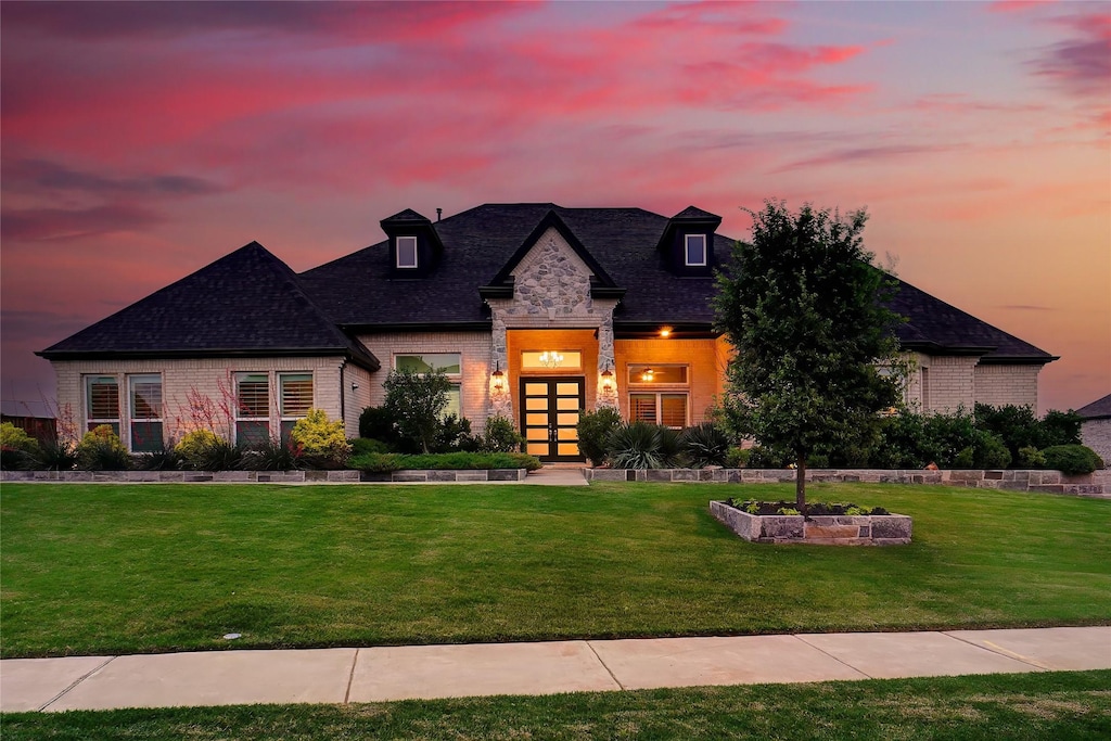 view of front of house featuring french doors and a yard