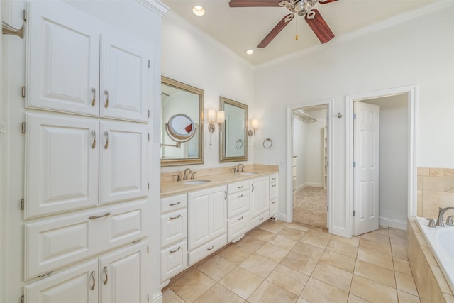 bathroom featuring ceiling fan, tile patterned flooring, tiled bath, vanity, and ornamental molding