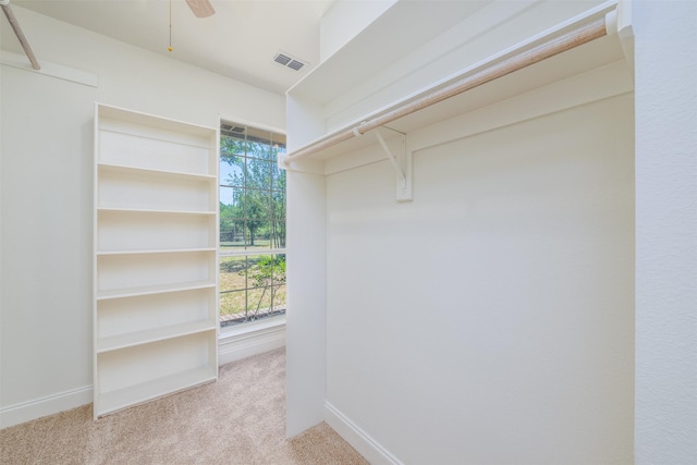 walk in closet featuring light colored carpet and ceiling fan