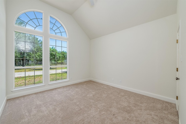 carpeted empty room featuring lofted ceiling