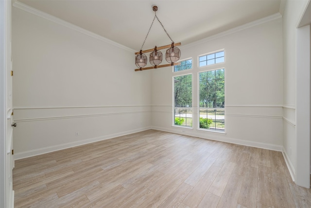 spare room featuring a healthy amount of sunlight, crown molding, and light hardwood / wood-style flooring