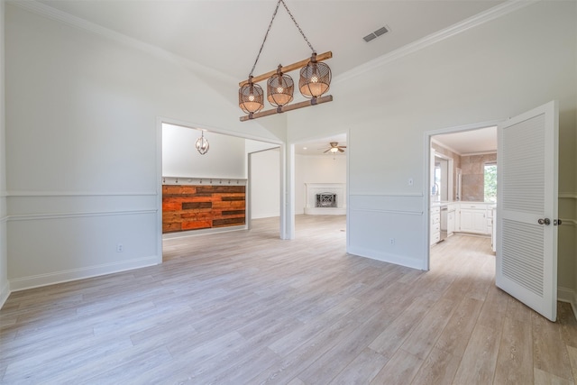 interior space with ceiling fan with notable chandelier, light wood-type flooring, and crown molding