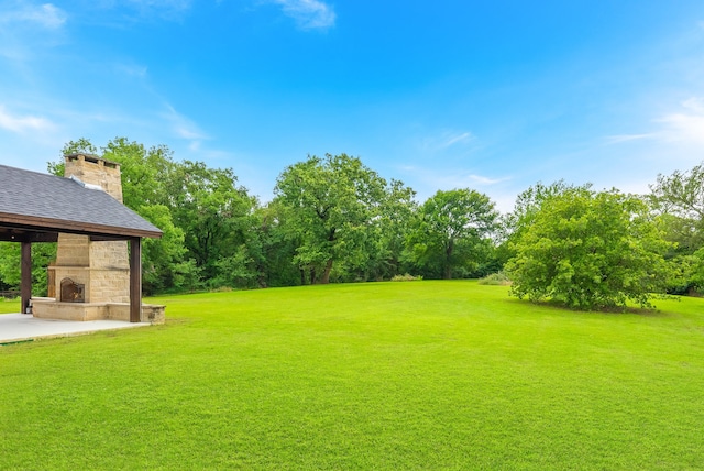 view of yard featuring an outdoor fireplace