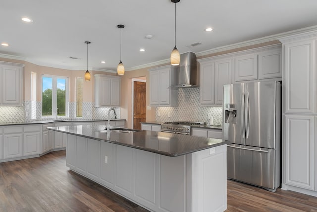 kitchen featuring stainless steel appliances, a kitchen island with sink, dark wood-type flooring, sink, and wall chimney range hood