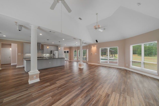 unfurnished living room with decorative columns, ceiling fan, high vaulted ceiling, and dark hardwood / wood-style floors