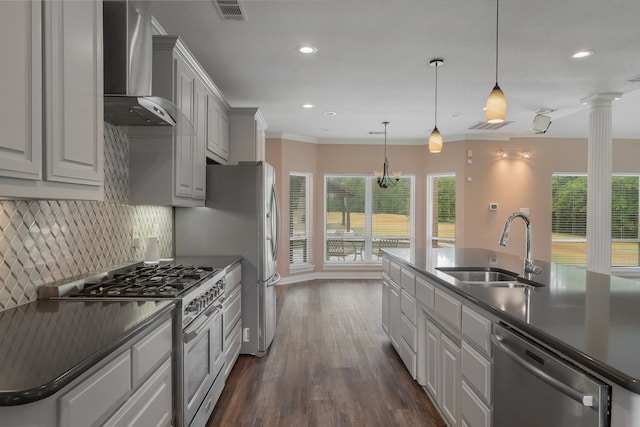 kitchen with wall chimney exhaust hood, stainless steel appliances, dark wood-type flooring, crown molding, and sink