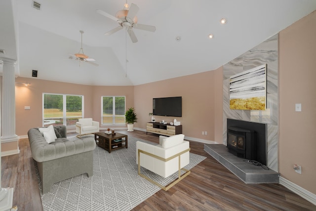 living room with dark hardwood / wood-style flooring, high vaulted ceiling, a wood stove, and ceiling fan