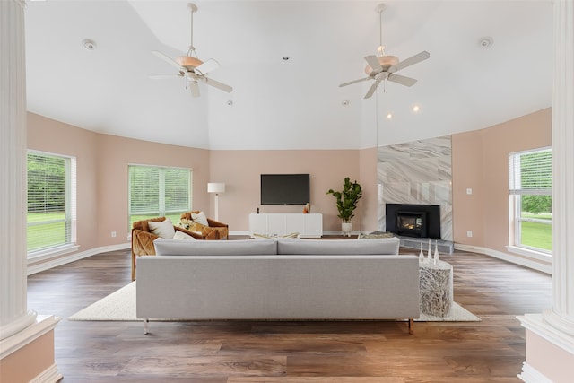 living room featuring a tiled fireplace, ceiling fan, dark hardwood / wood-style flooring, and high vaulted ceiling