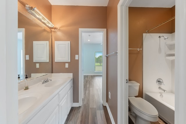 full bathroom featuring shower / washtub combination, vanity, wood-type flooring, and toilet