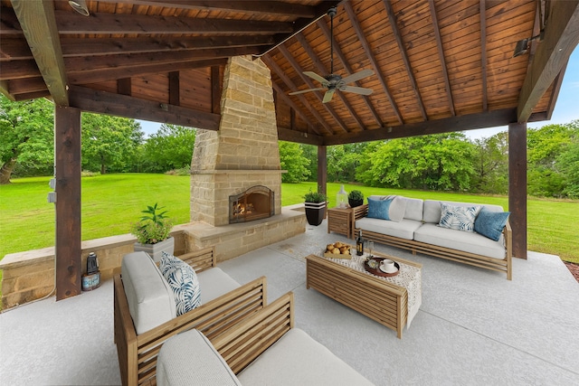 view of patio with an outdoor living space with a fireplace, ceiling fan, and a gazebo