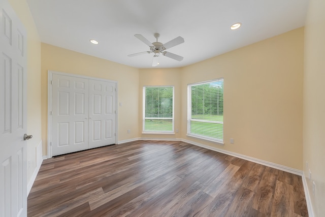 unfurnished bedroom featuring dark hardwood / wood-style floors, ceiling fan, and a closet