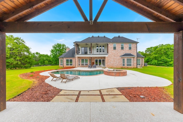 view of pool with a lawn, a patio area, ceiling fan, and an in ground hot tub