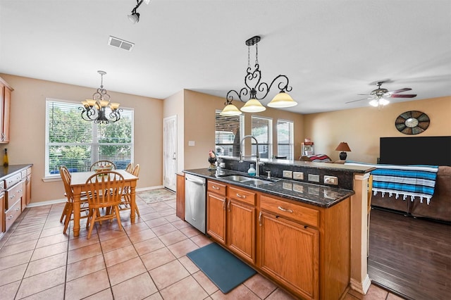 kitchen featuring plenty of natural light, dishwasher, decorative light fixtures, and sink