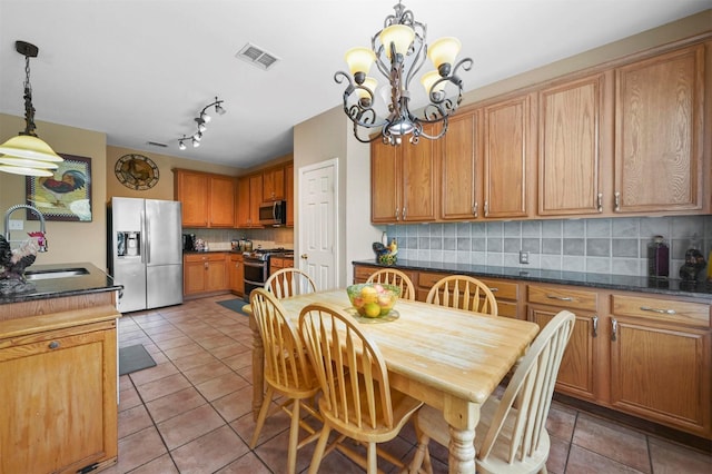 tiled dining space featuring sink and an inviting chandelier